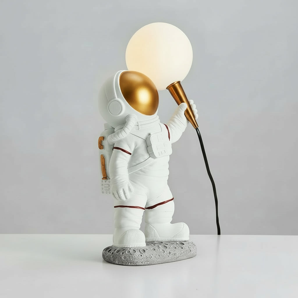 Table lamp shaped like an astronaut holding a light bulb
