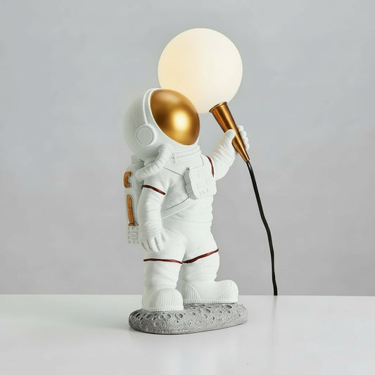Table lamp shaped like an astronaut holding a light bulb