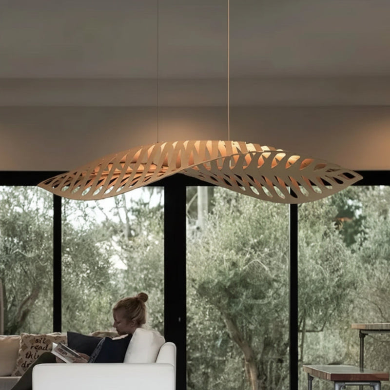 Modern pendant light hanging in a room with a view of trees outside