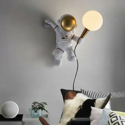 Wall lamp shaped like an astronaut with a gold helmet in a room setting.