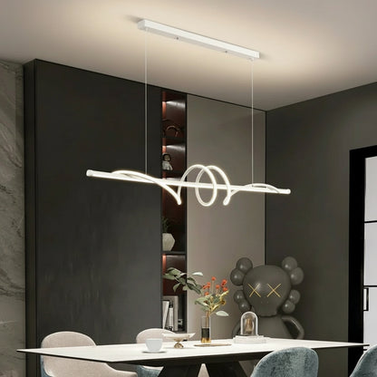 Modern interior design with a sleek light fixture, gray sofa, and decorative items.