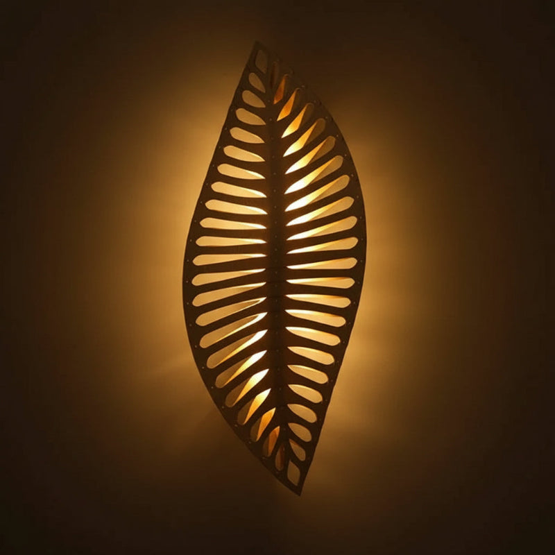 Decorative wall light fixture with leaf pattern on a neutral background