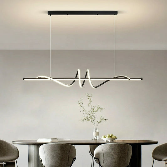 Modern pendant light hanging above a dining table with chairs in a minimalistic room.