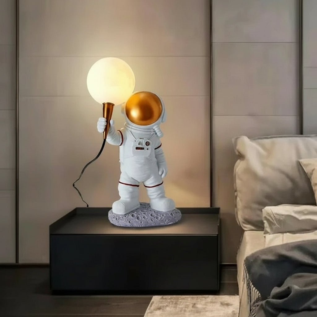 Spaceman-shaped table lamp on a side table with a neutral background